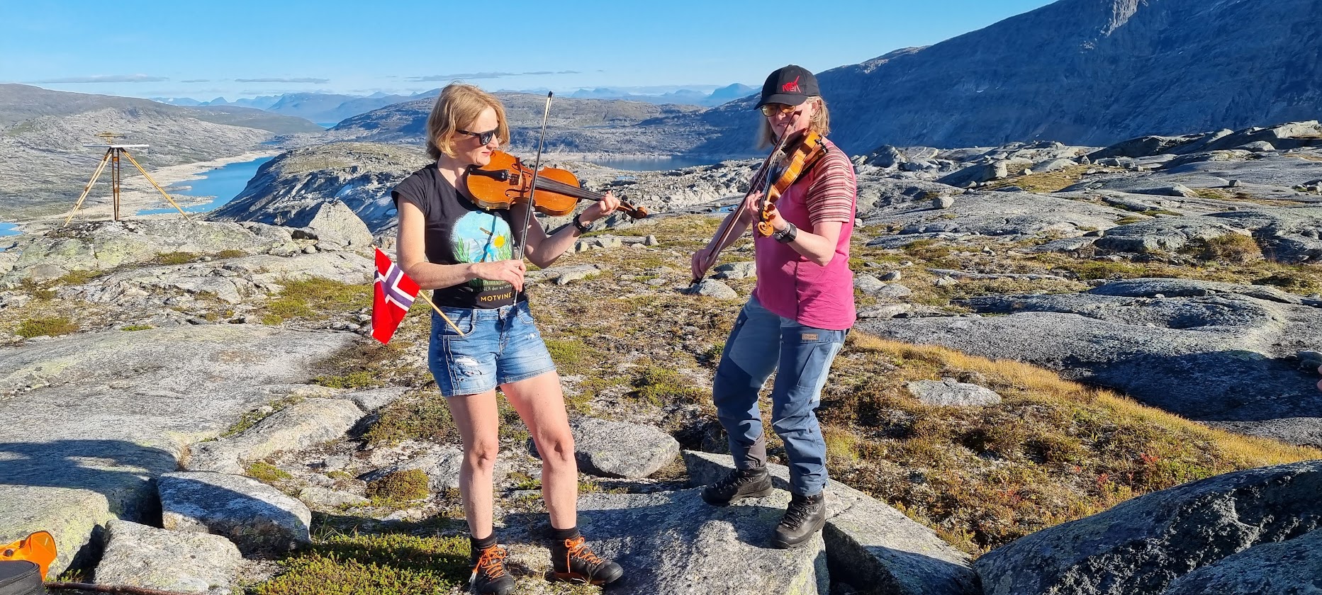 To damer som spiller fele på fjelltopp