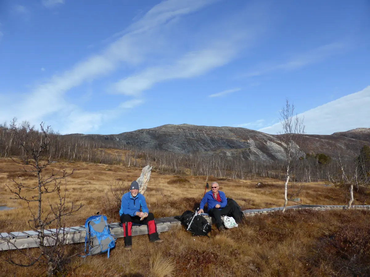 To dunadsarbeidere har pause på en klopp på fjellet