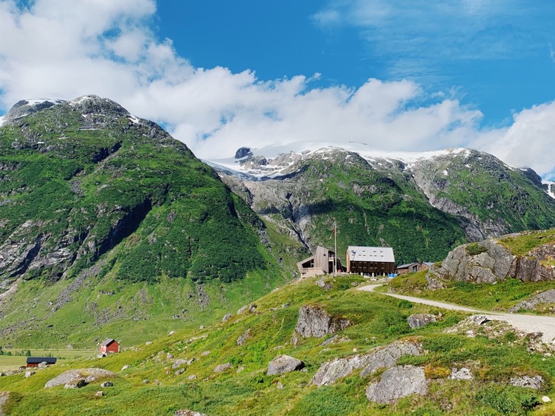 Moderne turisthytte i fjelldal.