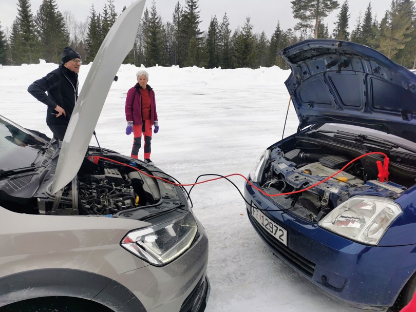 Bil med flatt batteri får strøm av annen bil.