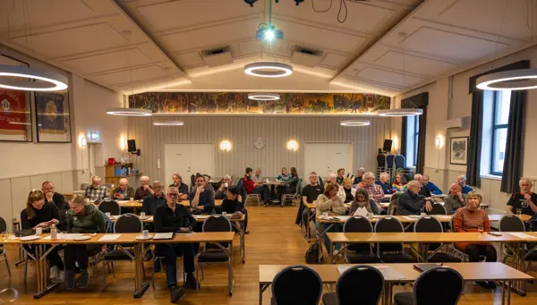 Ca 40 personer samlet i en konferansesal med klasseromsoppsett