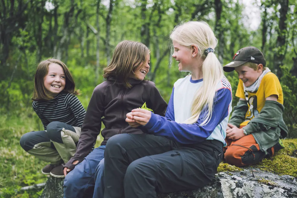 Barn som sitter i skog