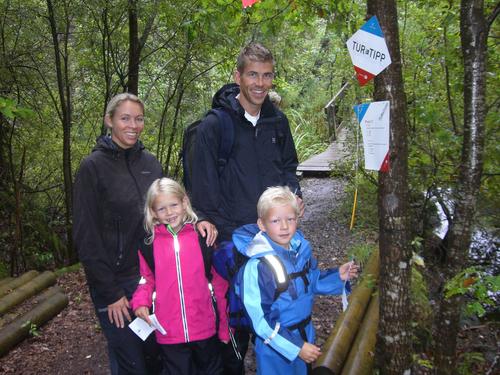 Familie som går tur i skogen på kom deg ut dagen