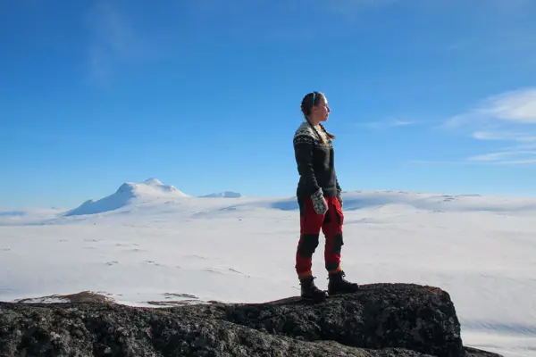 Jente beundrer utsikten mot vinterdekte fjell og vidder