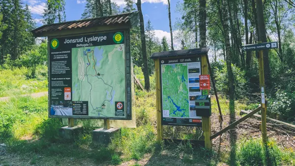 To kartavler i enden av en parkeringsplass, med skogen i bakgrunnen