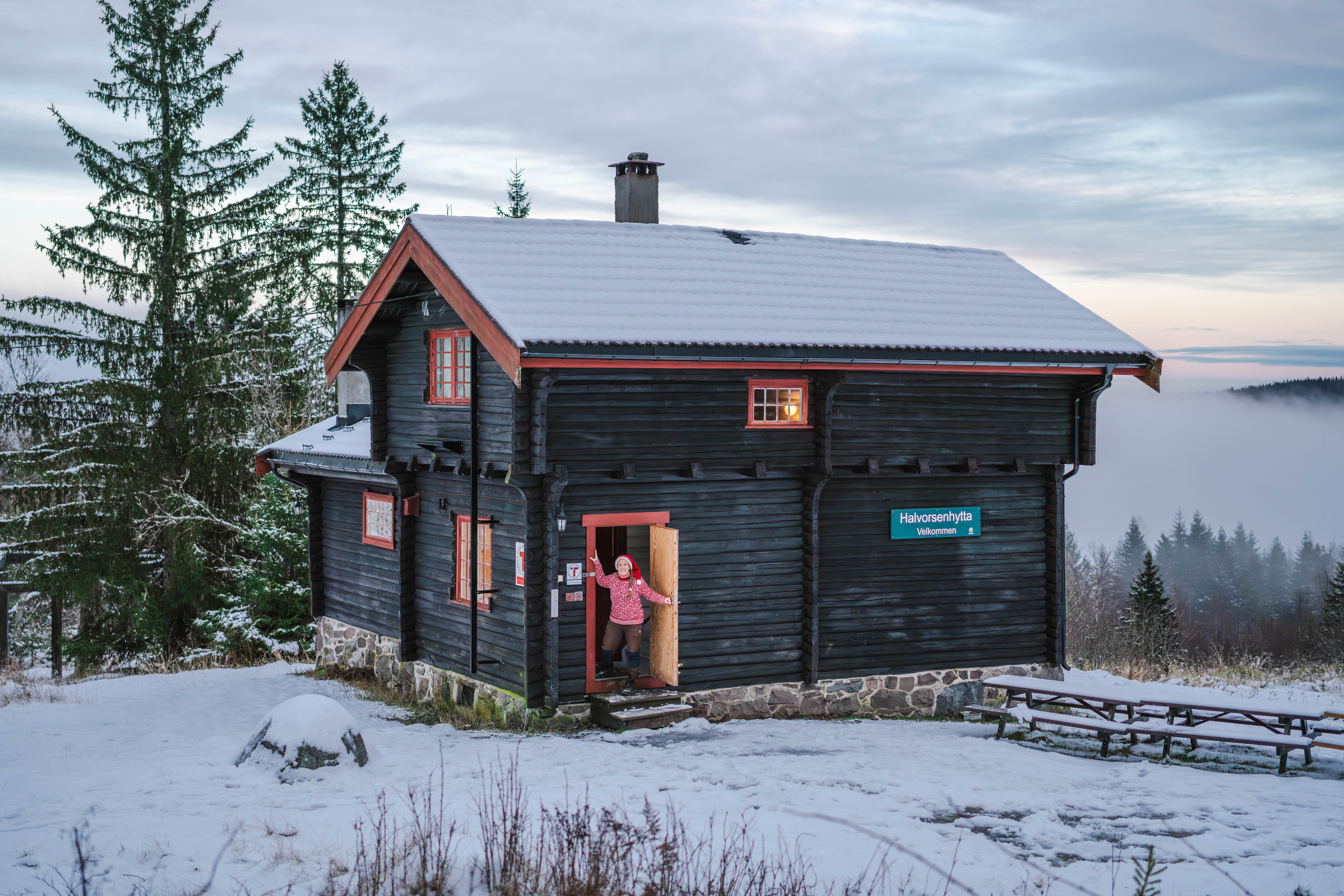 person i en døråpningen til en hytte
