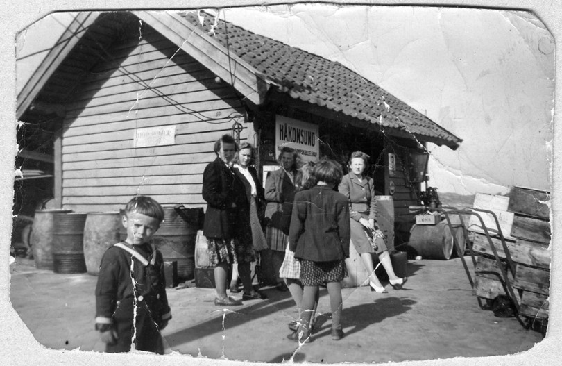 gamalt svart kvitt bilde med mennesker og trehus