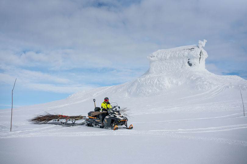 Jøkulhytta og en snøscooter lastet med kvist