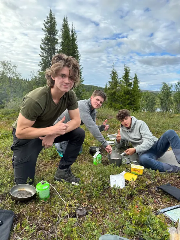 Gutter lager mat på gassbrenner ute