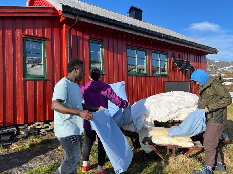 Frivillige er på dugnad og skifter sengklær på hytten Simlebu