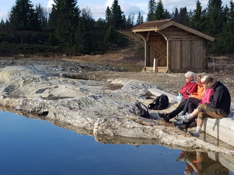 Gapahuk på fjellet, rastende turgåere utenfor.