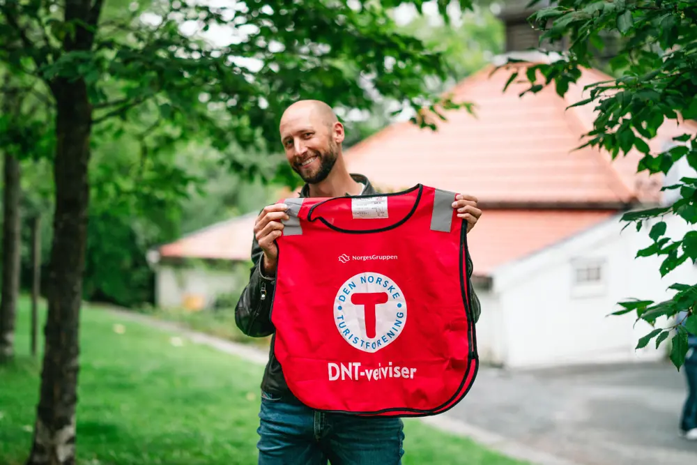 Person som holder opp en DNT-vest
