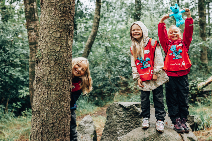Barn leker i skogen med Turbobamse