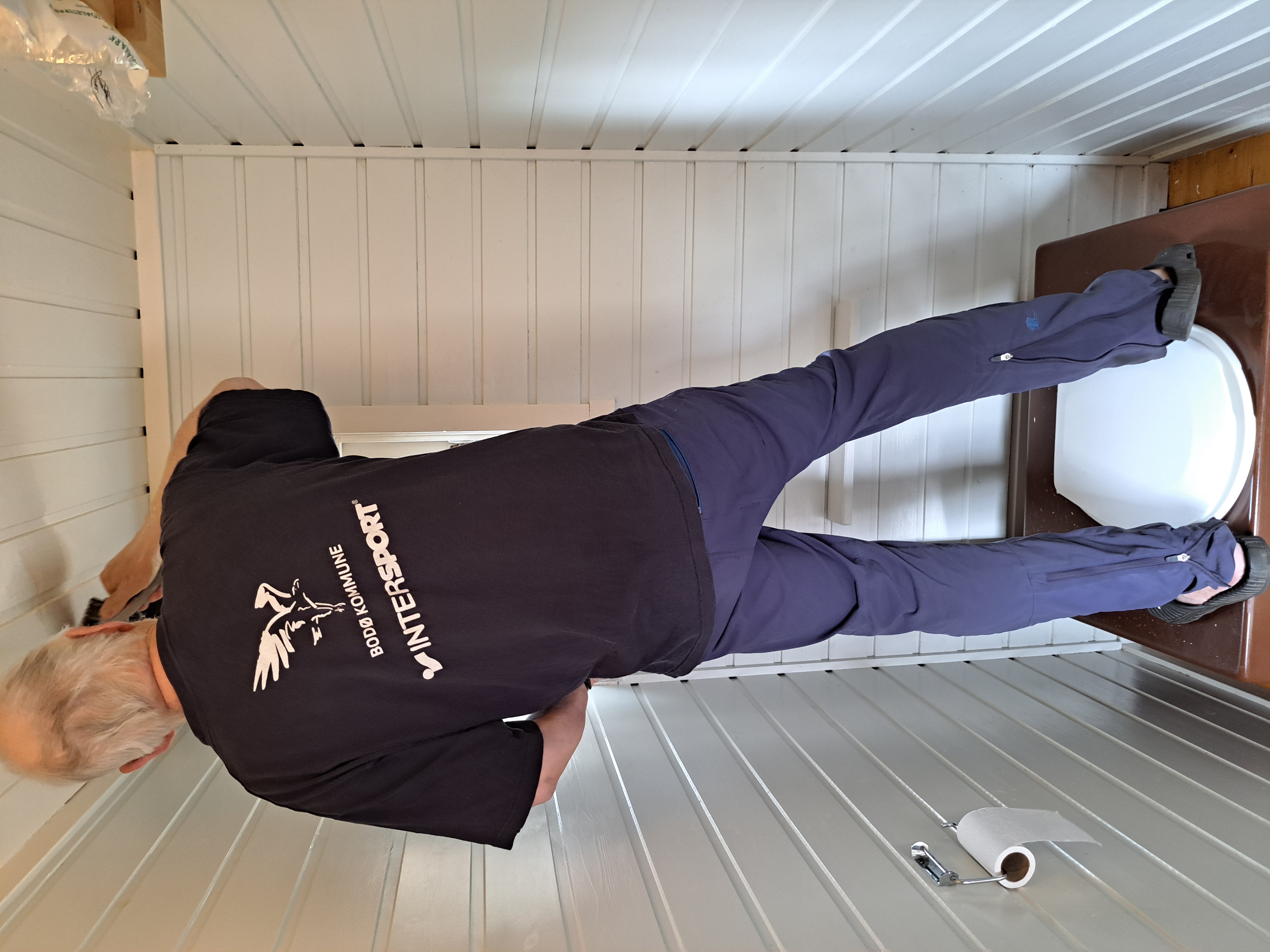 Mann st&aring;r p&aring; dobenk og maler tak i hvit farge