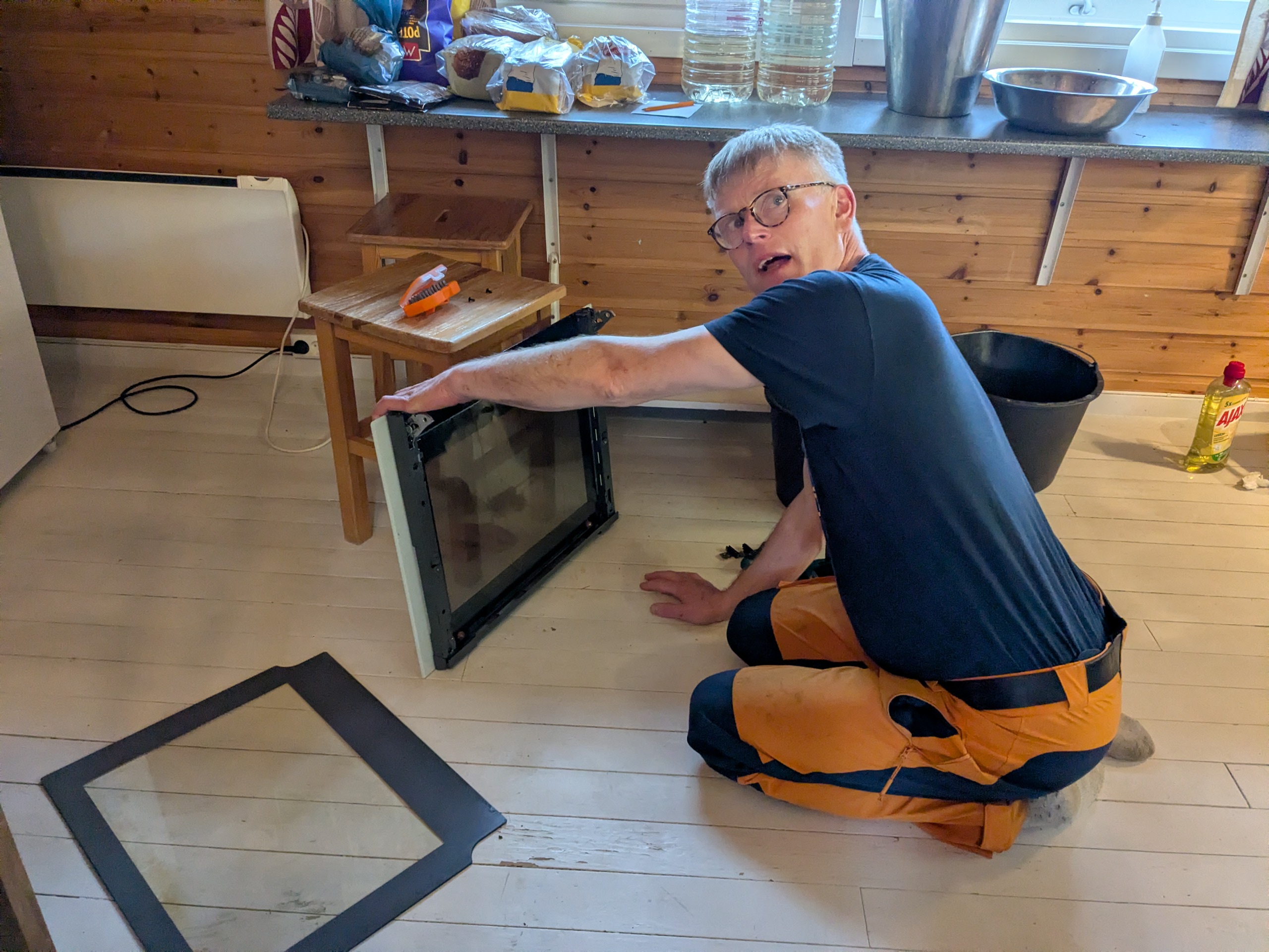 Mann med briller jobber med d&oslash;r til steikovn