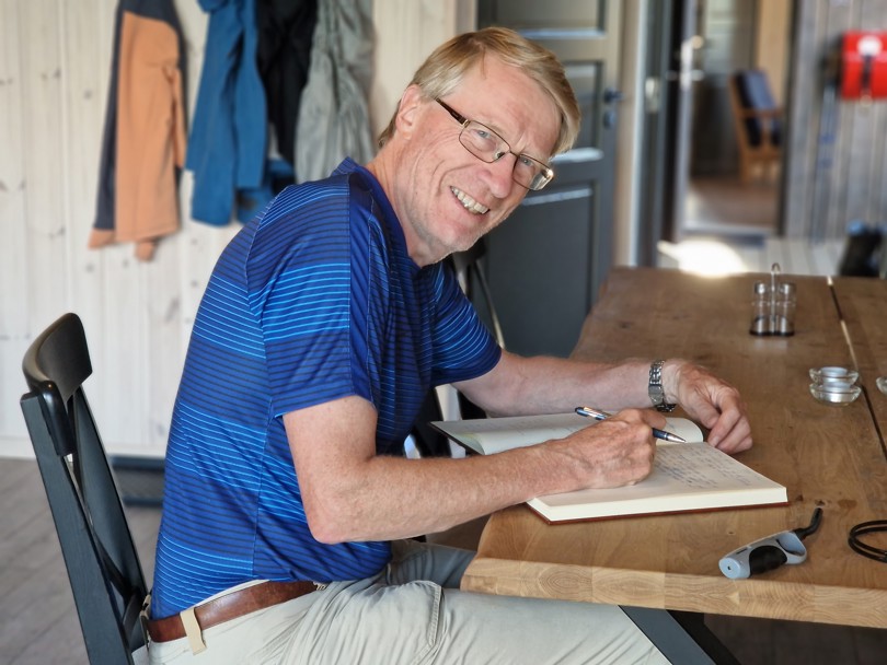 Karsten skriver i koieboka på Vassfarskoia.