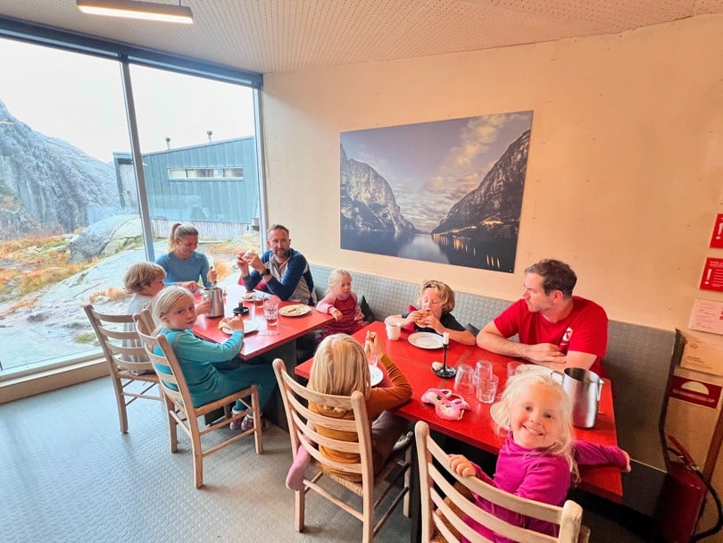 Familier samlet rundt middagsbordet inne i en hytte.