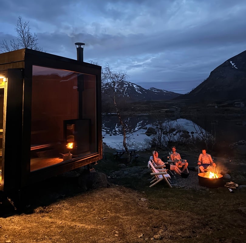 Tre personer som sitter utenfor en badstue