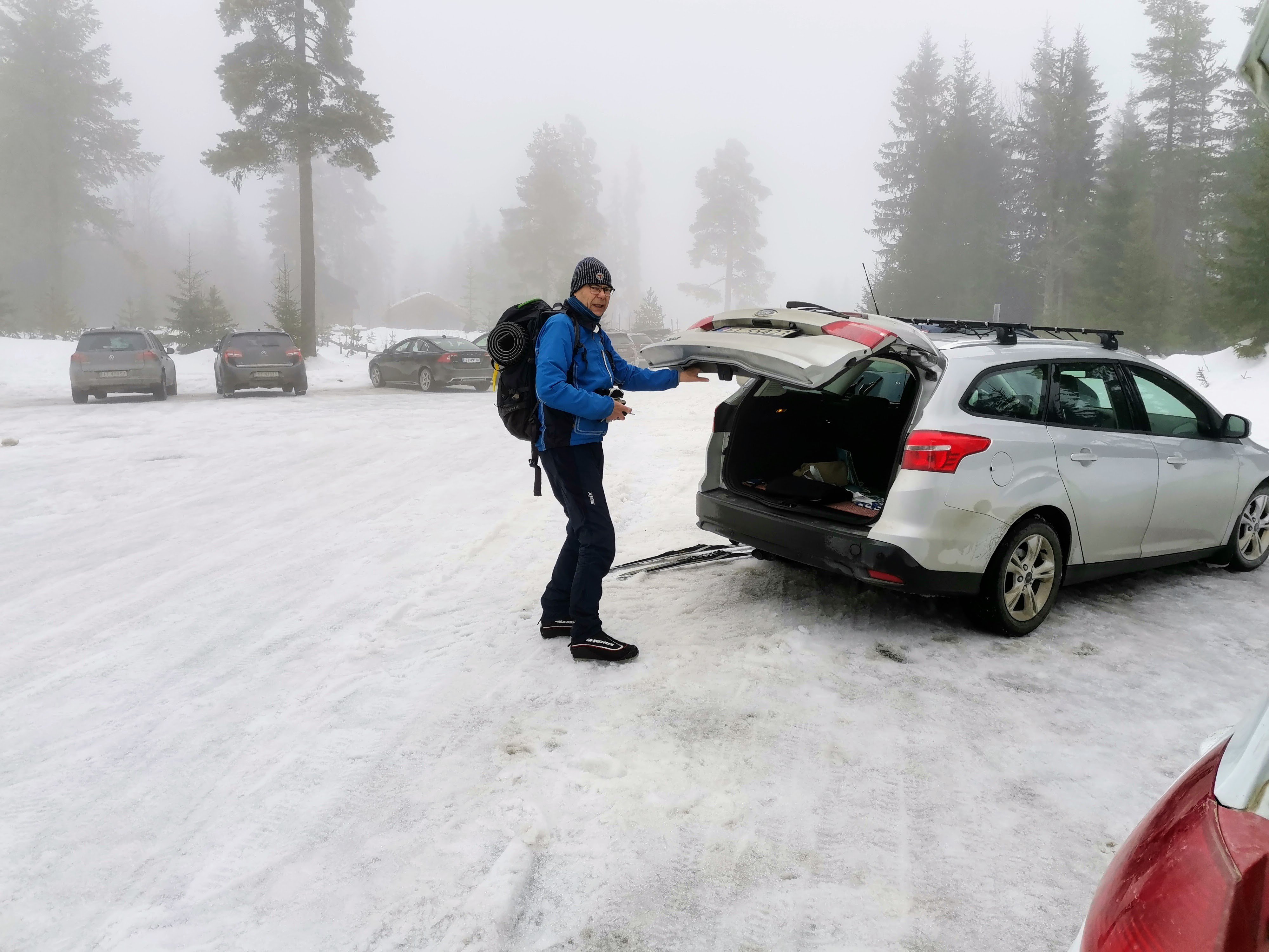 Mann tar ut ski fra bilen