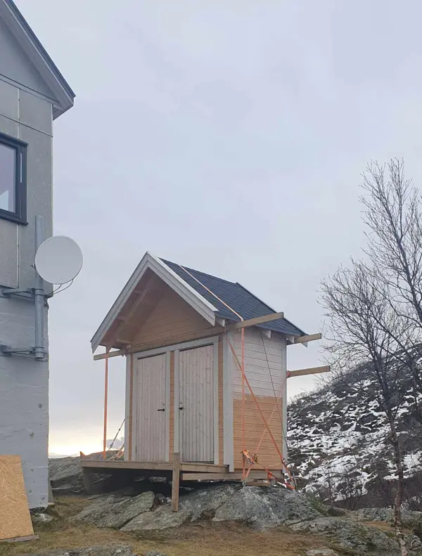 Liten bygning sikret med stropper og whire