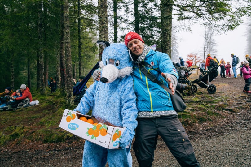 Mann og maskot i bamsekostyme.
