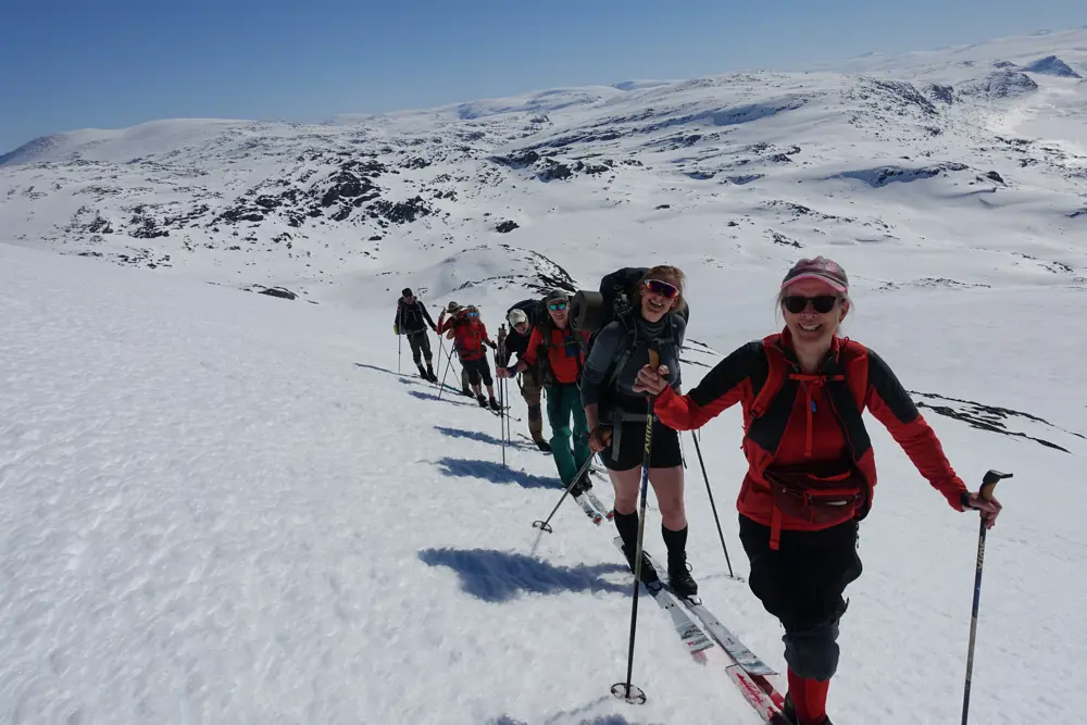 Rekke med skigåere i fjellet