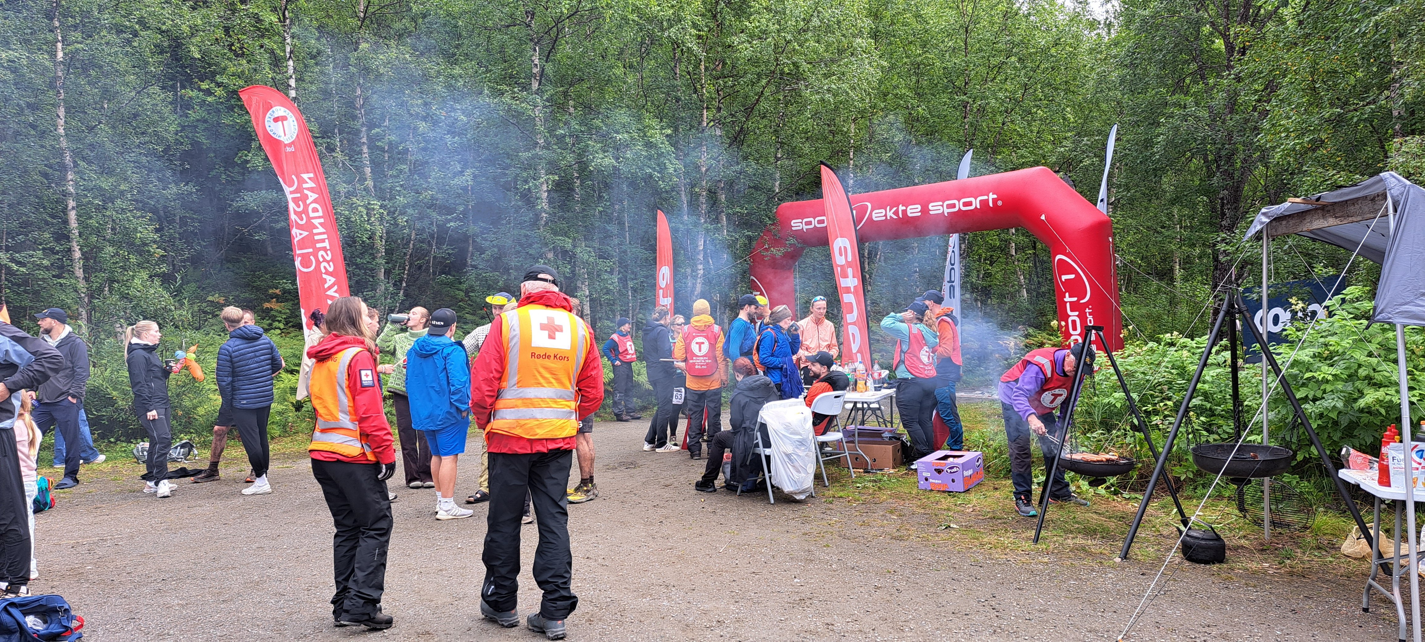 Mennesker som st&aring;r ved m&aring;lomr&aring;det til et fjell&oslash;p med ryggen til.