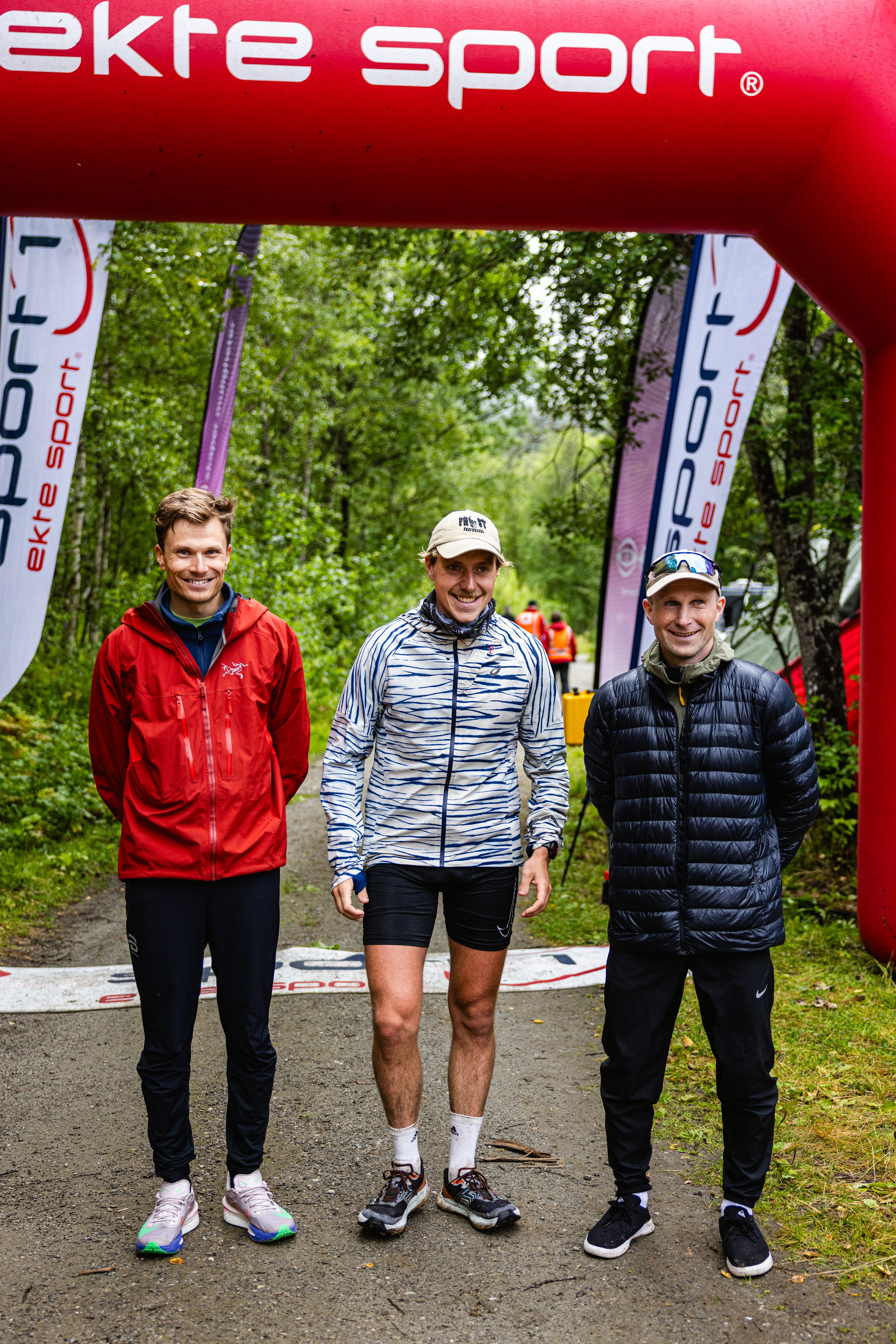 Tre mannfolk smiler til kamera etter &aring; ha fullf&oslash;rt fjell&oslash;p.