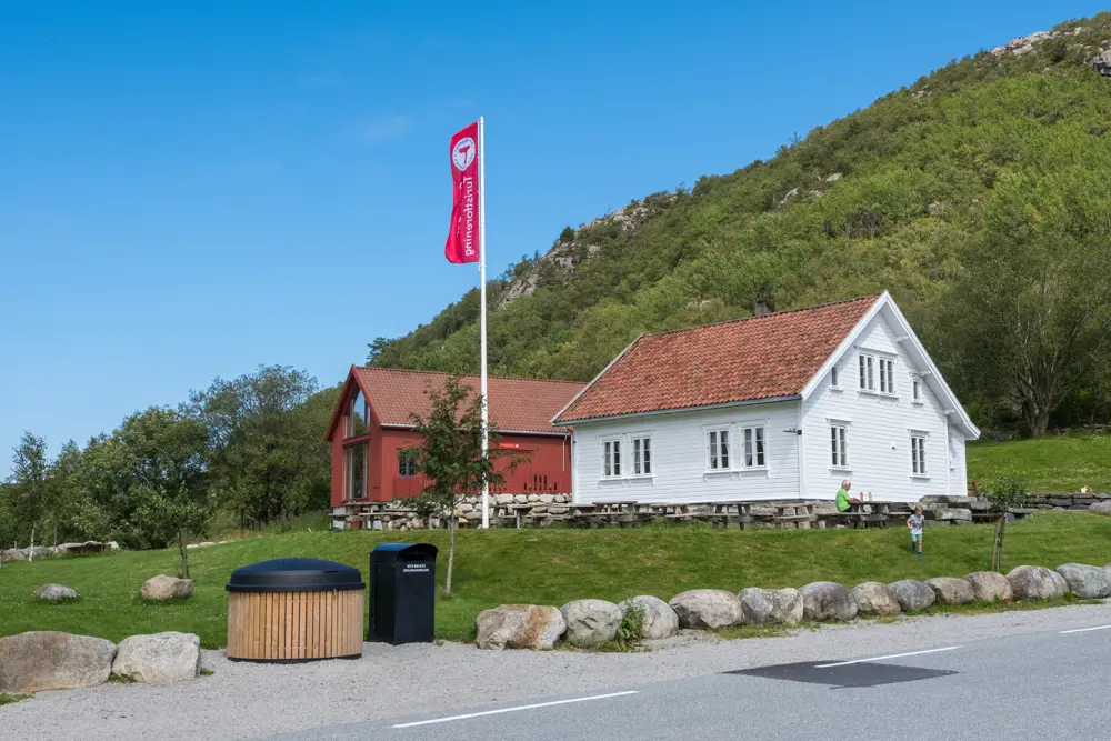 Bilde av det hvite huset på Gramstad med flagg i front.