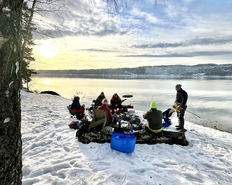 Bildet viser flere padlere rundt et bål