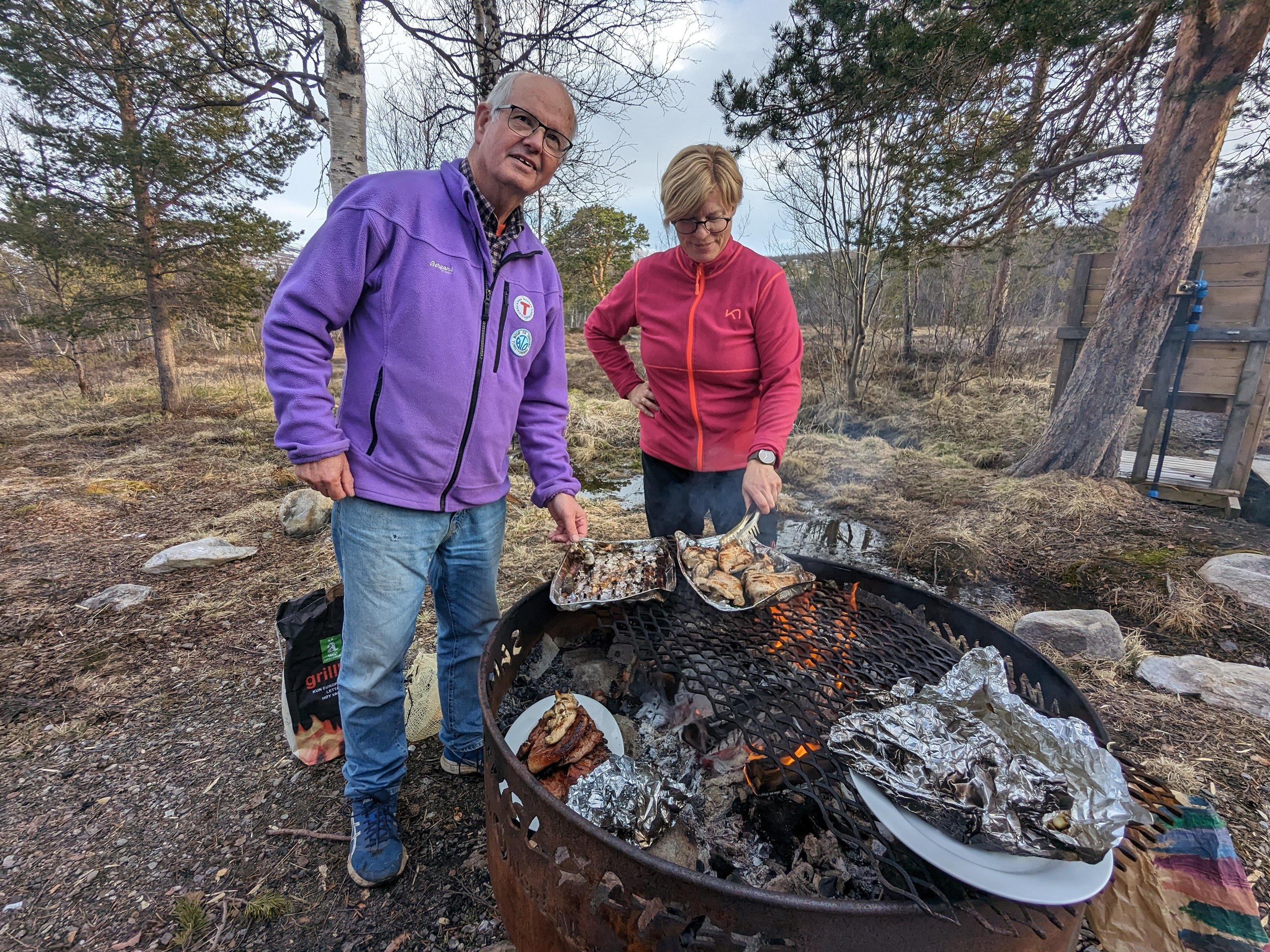 En mann og ei dame griller middagsmat