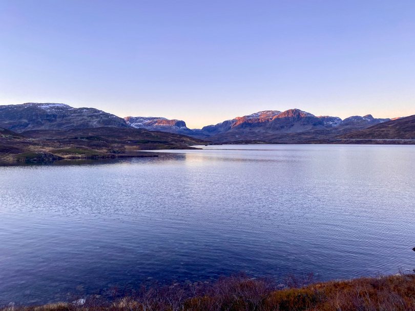 Lilla solnedgang, med fjell som speiler seg i Ståvatn ved Haukeliseter fjellstue