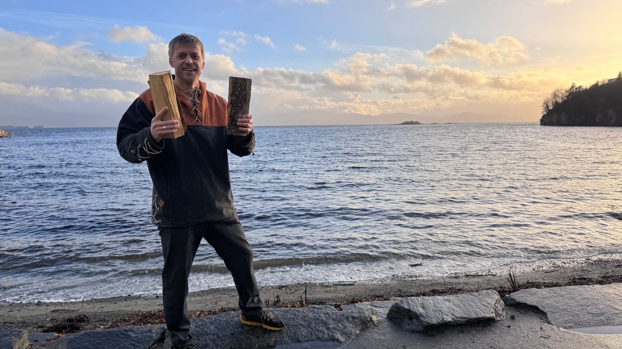 Mann st&aring;r med to vedkubber foran sj&oslash;