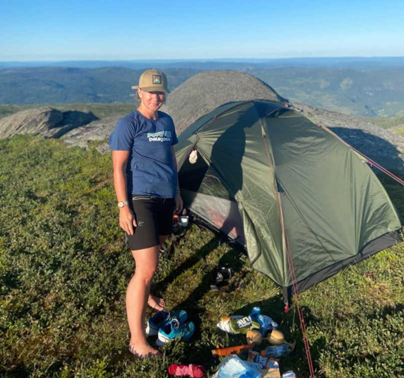 Dame på telttur i fjellet.