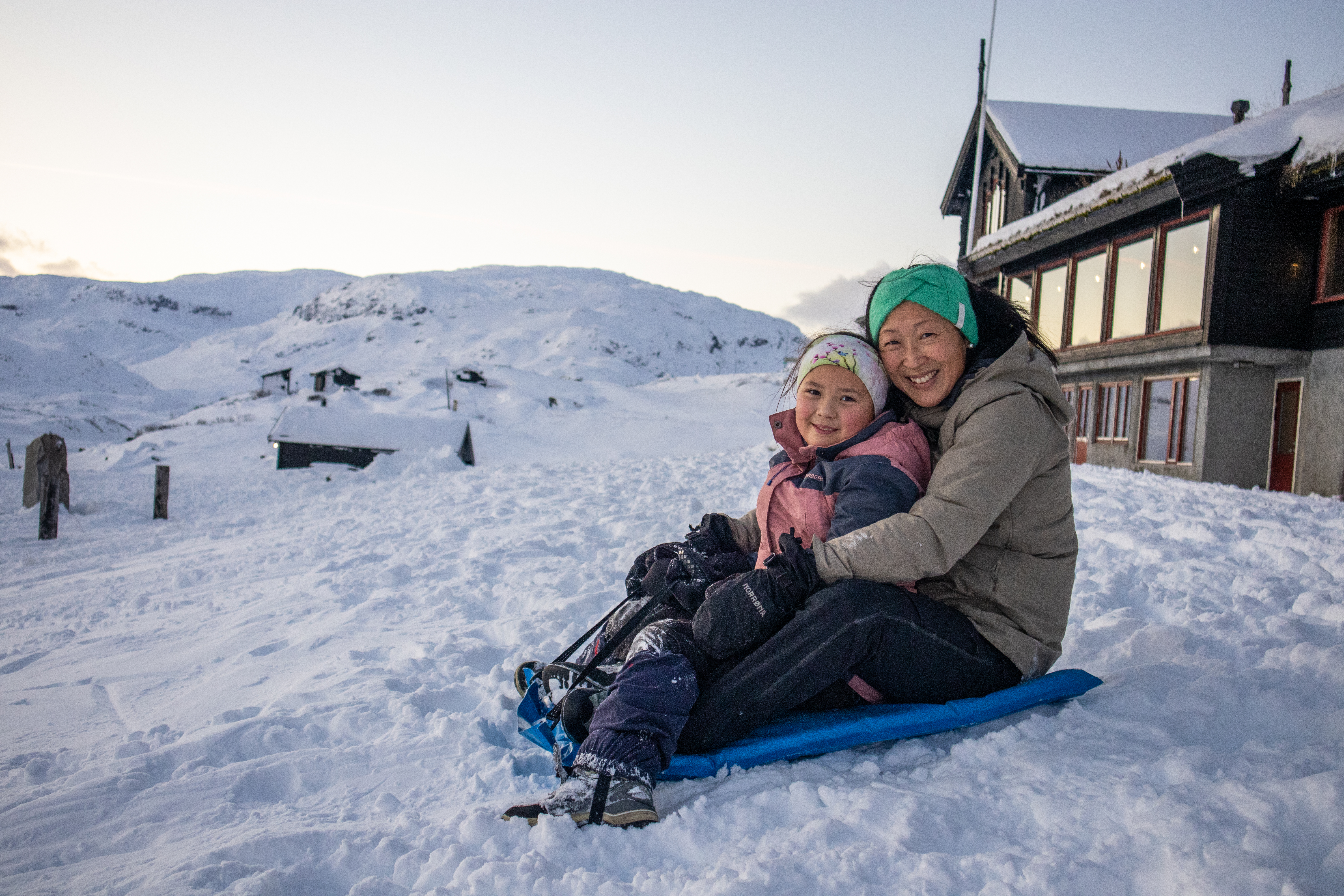 En mor og datter p&aring; en akematte. Fjell og sn&oslash;