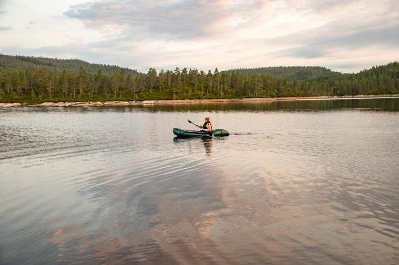 Person i en packraft midt ute på en innsjø