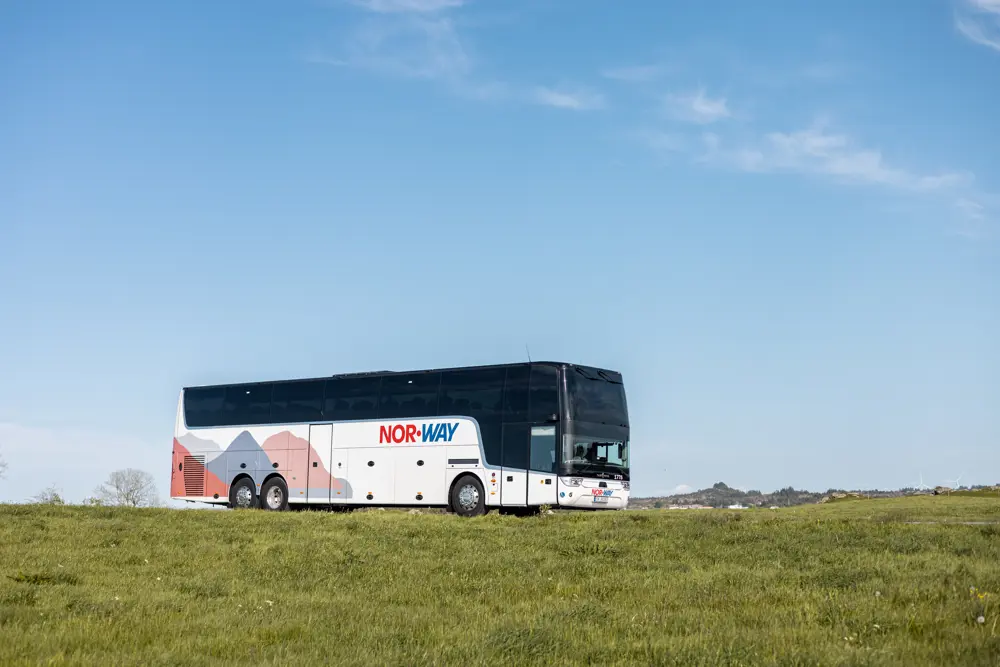 En buss som kjører i grønt landskap