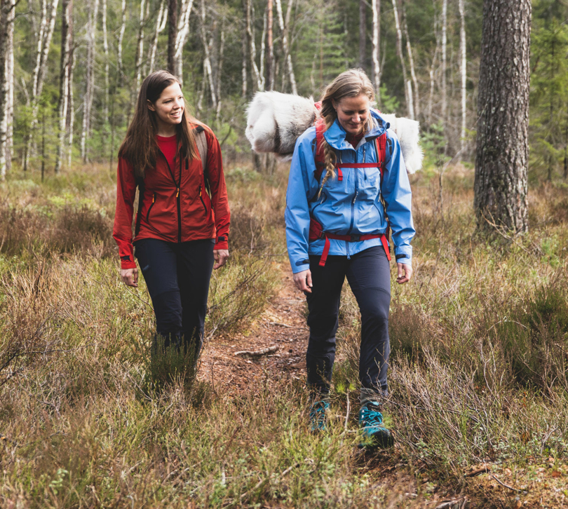 To personer går på tur i skogen.