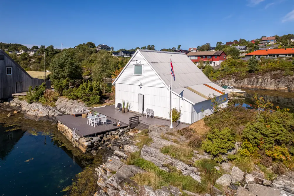 kvit hytte ved fjorden