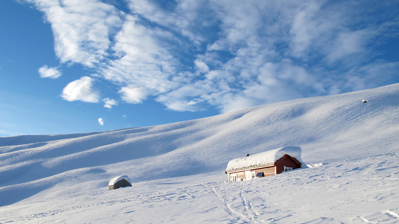 Hytte i snødekt landskap