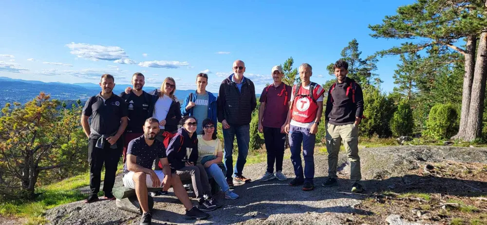 Mennesker som står på rekke på en fjelltopp