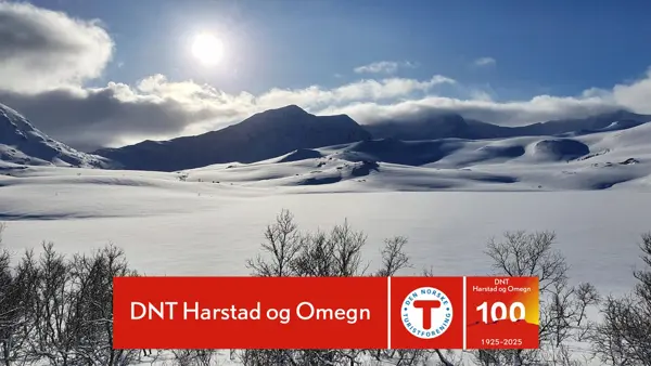 Vinterlandskap på fjellet med DNT Harstad kubileumslogo