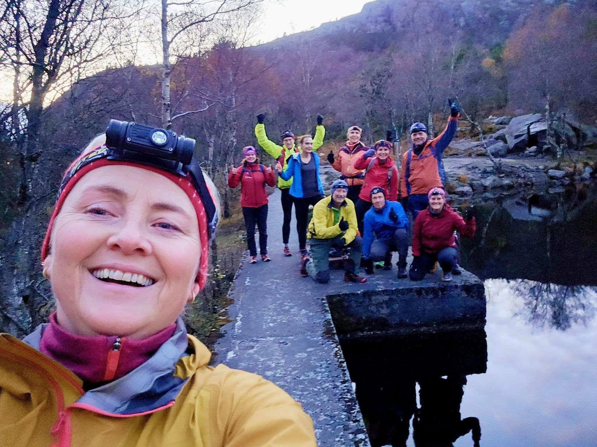 Kvinne tar selfie med masse andre turgåere i bakgrunnen,