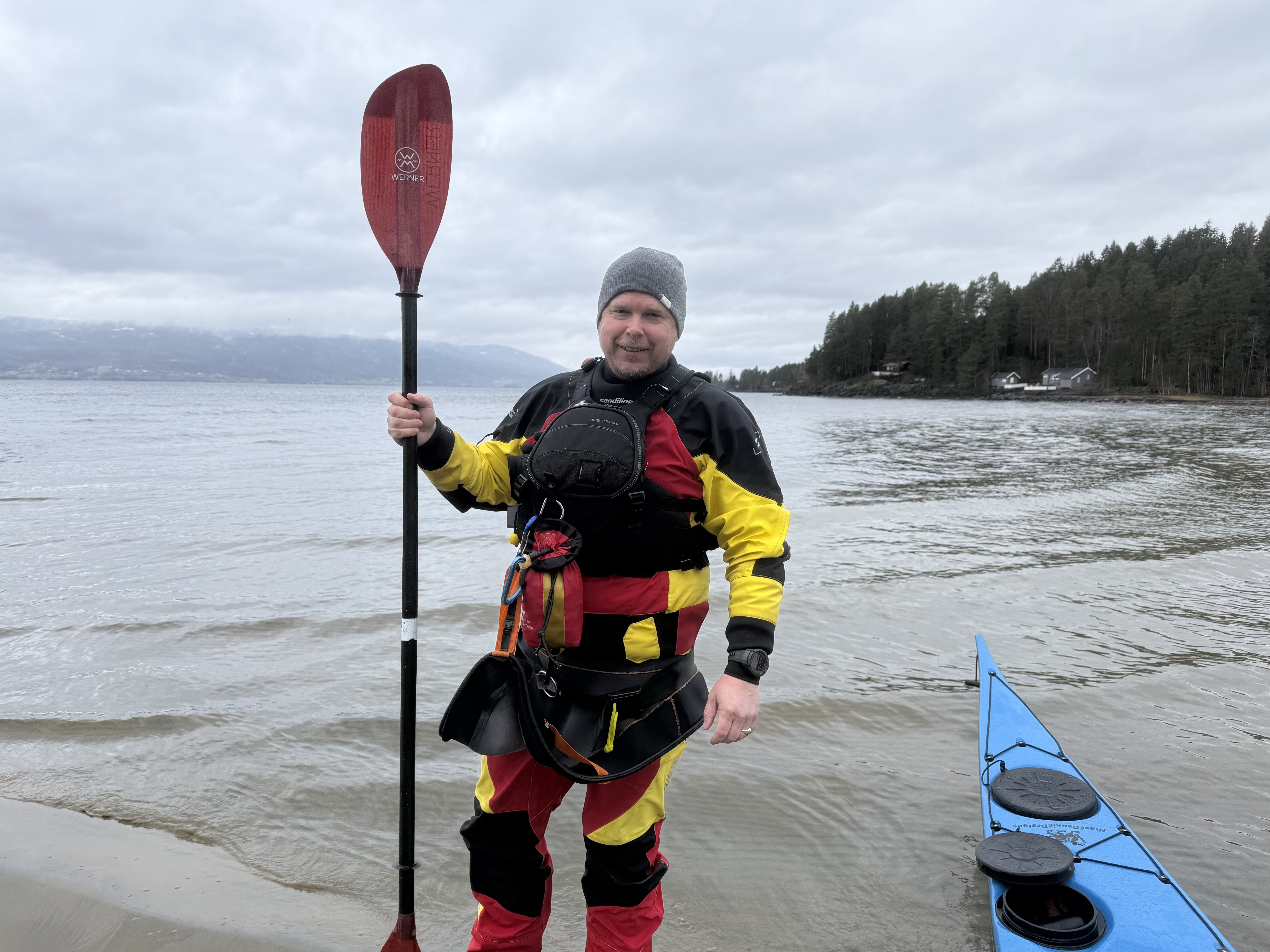 Bildet viser Ruben Sanden, han st&aring;r p&aring; en strand med kajakk og &aring;re.