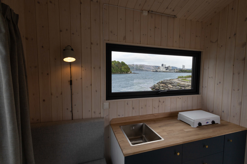 interiør hytte, sittegruppe og flott utsikt utover fjordlandskap