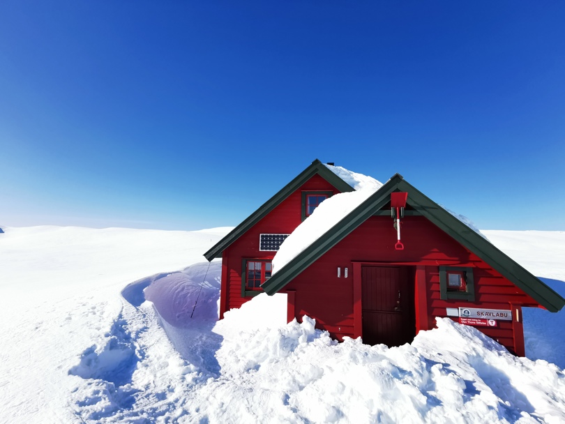 Rød hytte i vinterfjellet