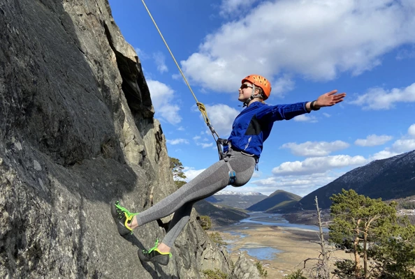 Ung fjellklatrer henger i fjellvegg