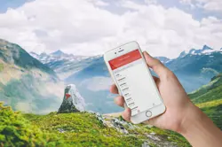 Telefonskjerm med betalingsapp foran flott fjellandskap