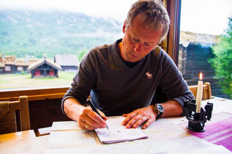 Henning skriver seg inn i hytteboka dagen før avreise 
