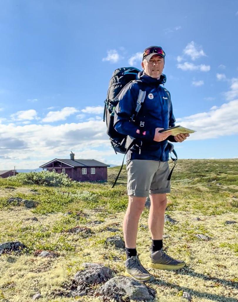 Henning med kart i hendene og Oskampen i bakgrunnen. 